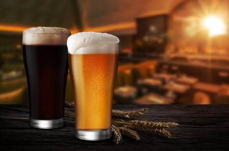 Glasses of Light Beer and Dark Beer with wheat on the bar counter in the restaurant at night, with copy spaceの写真素材