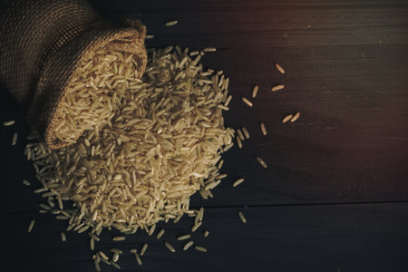 Sheaf yellow rice and white rice and organic jasmine rice on wooden tableの写真素材