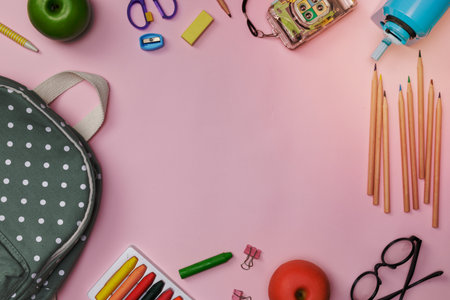 Creative flatlay of education pink table with backpack, student books, shoes, colorful crayon, eye glasses, empty space isolated on pink background, Concept of education and back to schoolの写真素材