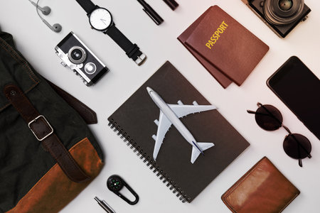 Top view mockup of Traveler's accessories with passport, books of travel plan, wallet, camera, hat, backpack and airplane toy isolated white background,Tropical travel conceptの写真素材