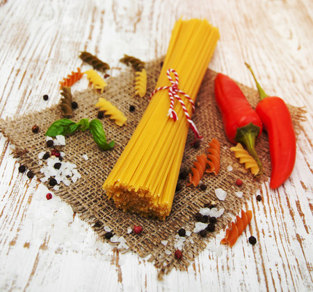 Italian ingredients - pasta, vegetables, spices on a  wooden backgroundの写真素材