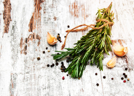 Garlic with rosemary and pepper on a old wooden backgroundの写真素材