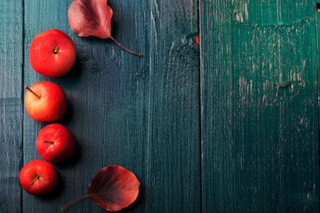 Red apples and leaves on a wooden blue, turquoise backgroundの写真素材