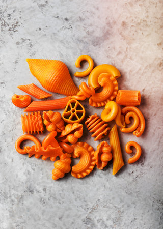 Pile of naturally colored orange pasta with carrot Stone backgroundの写真素材