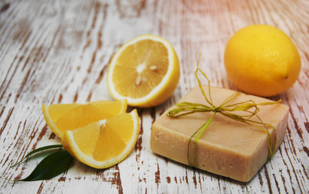 Piece of handmade lemon soap and fresh lemonsの写真素材