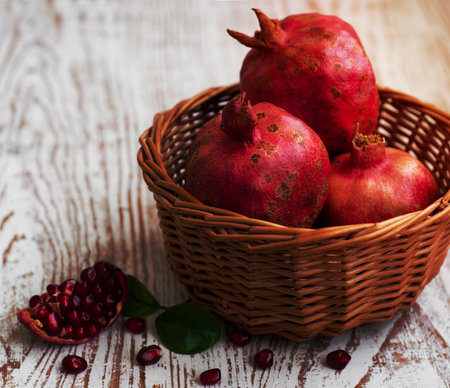 Basket with pomegranate on  old white wooden backgroundの写真素材