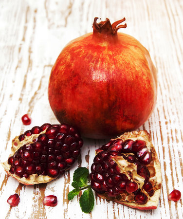 juicy pomegranates on a old wood backgroundの写真素材