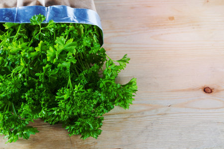 Curly parsley plant against wooden background. Landscape orientation. Copy space.の写真素材