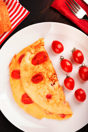 Omelette with tomatoes aon the white plateの写真素材