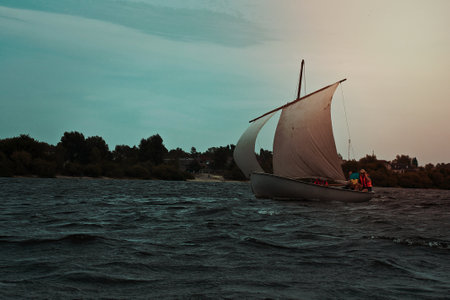 Sailboat floating on water gloomy landscape photo. Beautiful nature scenery photography with blurred background. Idyllic scene. High quality picture for wallpaper, travel blog, magazine, articleの写真素材