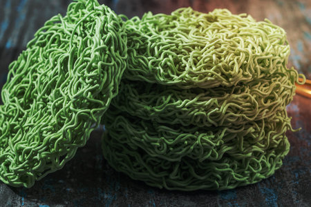 Green instant noodle on blue black wood background, top view, Asian food concept.の写真素材