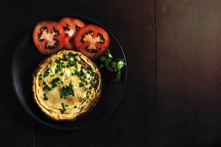 Omelet has tomato in plate isolated on wood background, top view, healthy breakfast food concept.の写真素材
