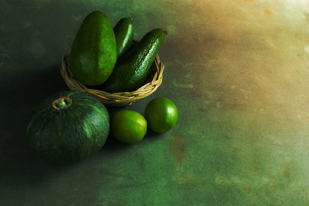 Avocado pumpkin green lemon on wood background copy space, top view, green fruit concept.