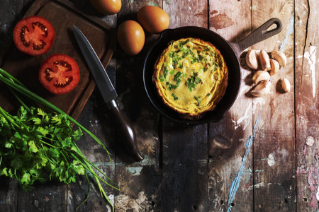 Omelet has onion in pan isolated on wood background, top view, healthy breakfast food concept.の写真素材