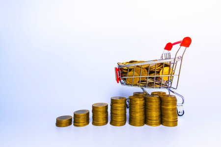 Business Finance and Money concept, Money coin stack growing graph with shopping cart on white backgroundの写真素材