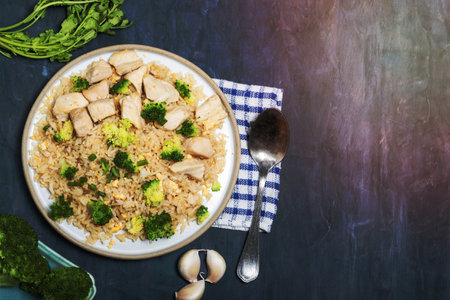 Fried rice dish with chicken breast have vegetable broccoli in plate isolated on wood background close up, top view, healthy food and drink concept.の写真素材