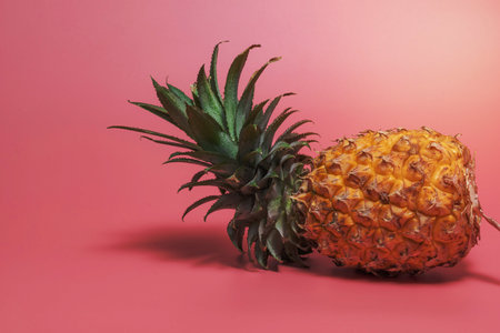 Pineapple isolated on pink background, top view, minimal healthy fruit food concept.の写真素材