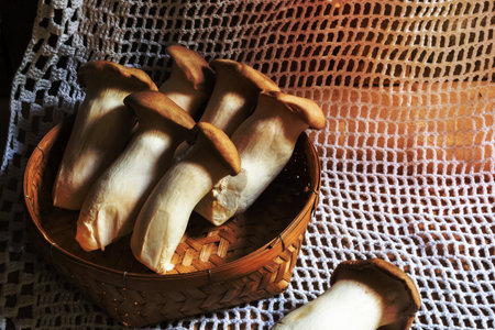 King oyster mushroom or erygii in basket on wood background closeup, copy space, healthy food concept.の写真素材