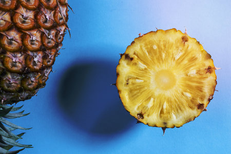 Pineapple sliced on blue background, top view, minimal healthy fruit food concept.の写真素材