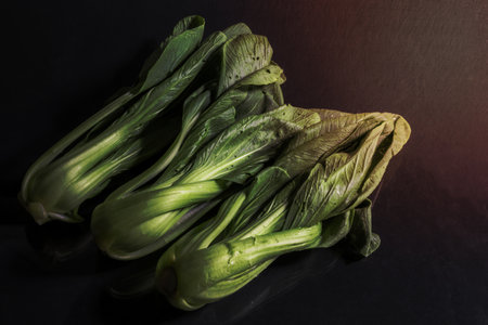 Bok choy vegetable on black wood background close up, top view, healthy food concept.の写真素材