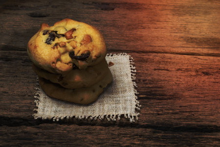 Cashew nuts raisin cookies stacked together on wood background, close up, food and drink concept.