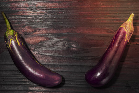 Eggplant isolated on wood background close up, top view, vegetable food concept.の写真素材