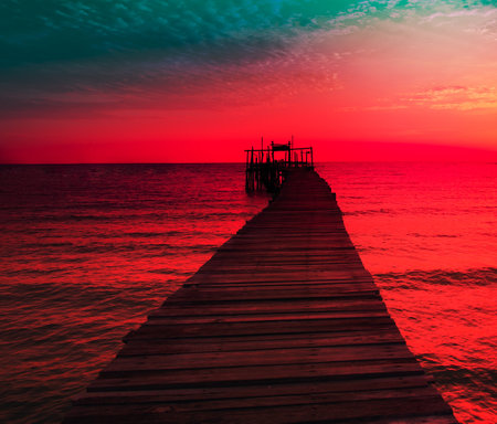 Seascape view sunset with A wooden pier that stretches out to the sea and cloudy sky for travel in holiday relax time as summerの写真素材