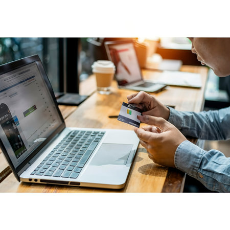 Asian man hand is pulling a credit card out of his pocket in order to complete online shopping on the computerの素材