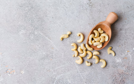 Cashew nuts in a wooden scoop . On a rustic background.online marketing.の素材