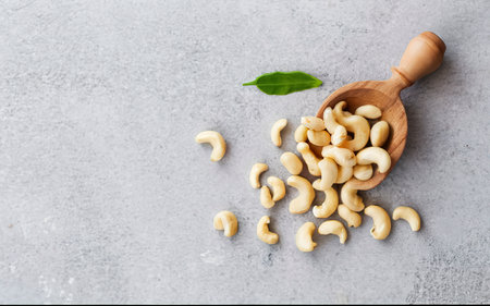 Cashew nuts in a wooden scoop . On a rustic background.online marketing.の素材