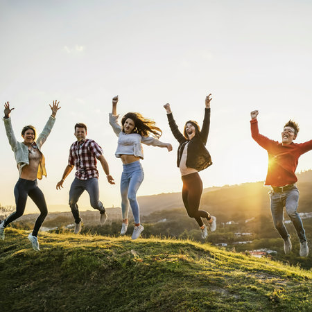 Group of friends jumping on top of hillの素材