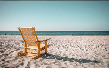 Wooden deck chair on a sandy beach in front of the seaの素材