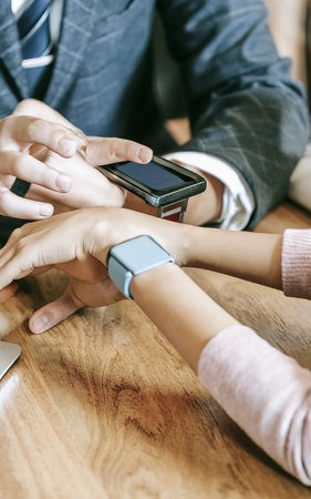 Close up image of Schoolchild in business suit using smart-watchの素材