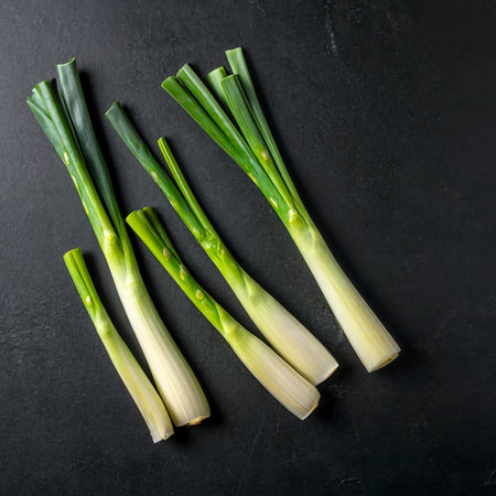 Minimal flat lay looking leeks view during slice progress over blackの素材