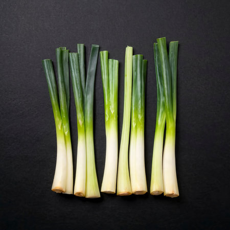 Minimal flat lay looking leeks view during slice progress over blackの素材