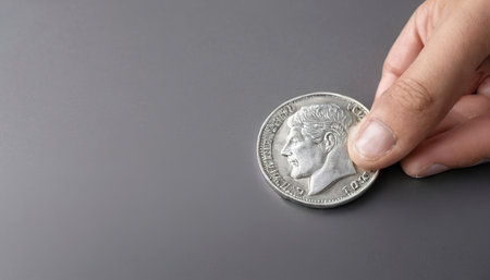 Hand and silver coin, concept of saving money for business operation, stable money in the futureの素材