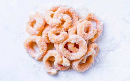 Frozen raw squid rings in breadcrumbs. Isolated on white backgroundの素材