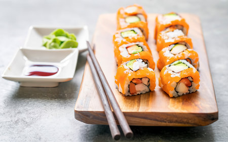 Salmon fish meat sushi roll maki on wood plate with wasabi and soy sauceの素材