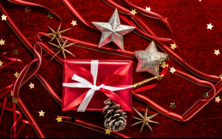 Shooting star and gift on red velvet background. Christmas decorationの素材