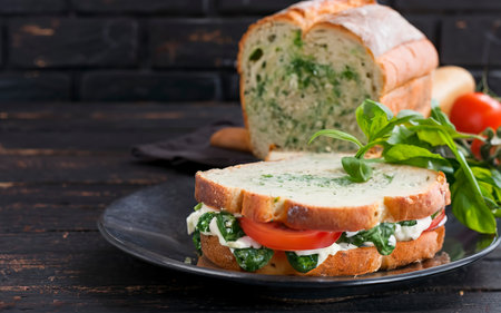 Spinach bread and a sandwich with cheese, tomatoes and herbsの素材
