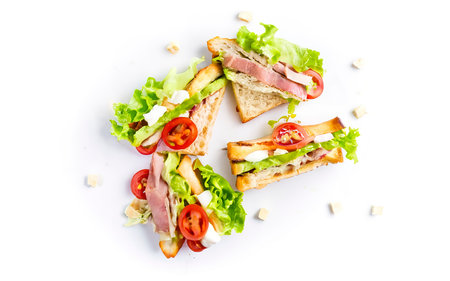 Toasted Club sandwiches with pork ham, cheese, tomatoes and lettuce Isolated on white backgroundの素材