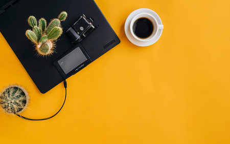 Laptop computer and coffee cup, with Camera and Cactus tree. External hard disk with USB on pastel background yellowの素材
