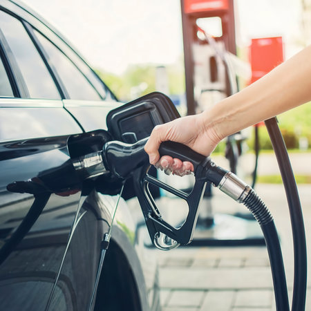 Hand refilling the car with fuel at the gasoline stationの素材