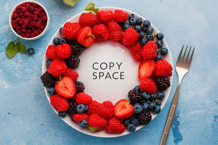 Fresh berries on a plate with copy space in the middle overhead viewの素材