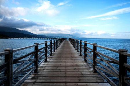 The wooden bridge stretches into the sea.With Mountain clouds and sky