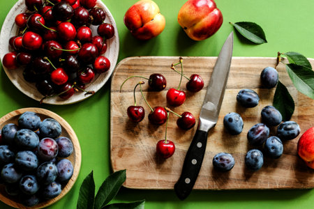 top view of fresh fruits such as red cherries, green cherry, plums, dark purple sloes