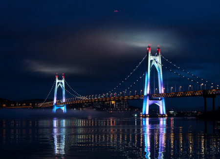 Illuminated suspension bridge at night with fog