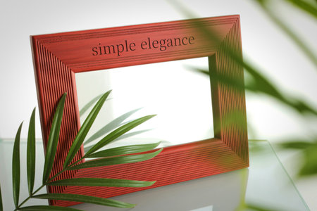 A close-up shot of a textured red wooden photo frame with the words simple elegance engraved on its...