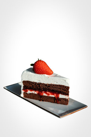 A rich slice of red velvet cake with creamy white frosting and a vibrant strawberry garnish sits on a sleek platter.の写真素材