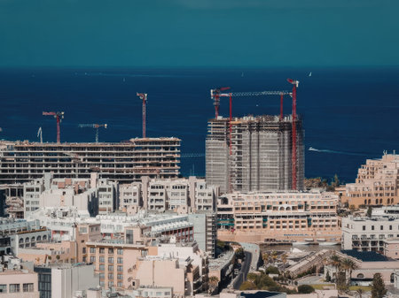 The image depicts a cityscape with several construction sites and buildings under development. The...